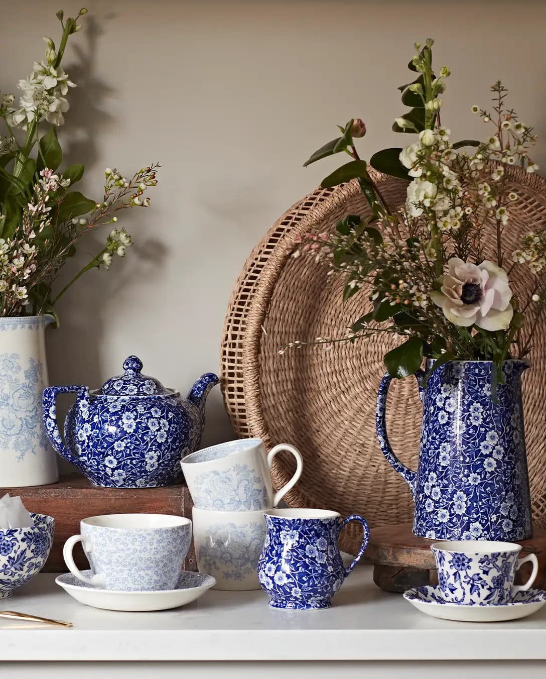 Kitchen cupboard displays dark blue Burleigh pottery tableware with ornaments