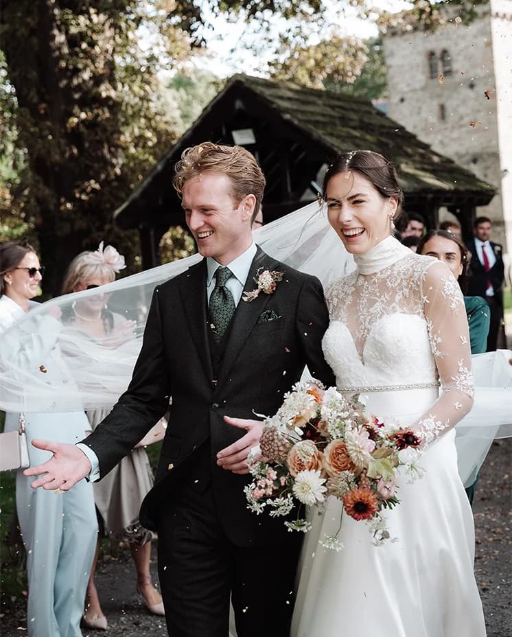 Guests throw confetti as the bride and groom exit the church after their wedding ceremony.