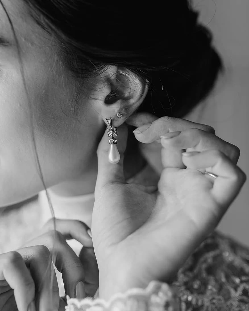 Bride puts on heirloom jewellery, earrings from her grandmother