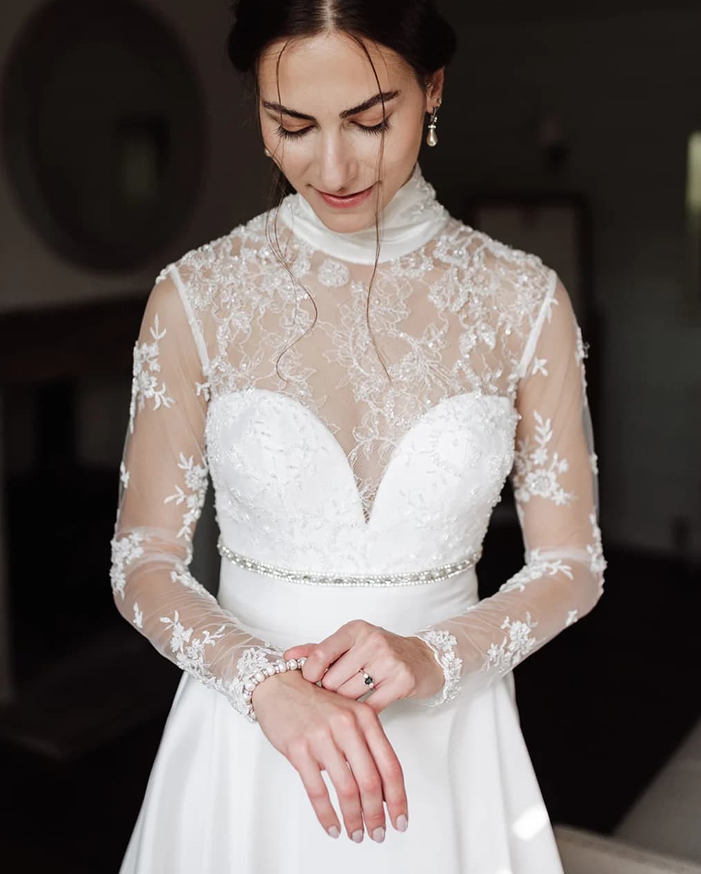 Bride puts on heirloom jewellery, a pearl bracelet from her mother.