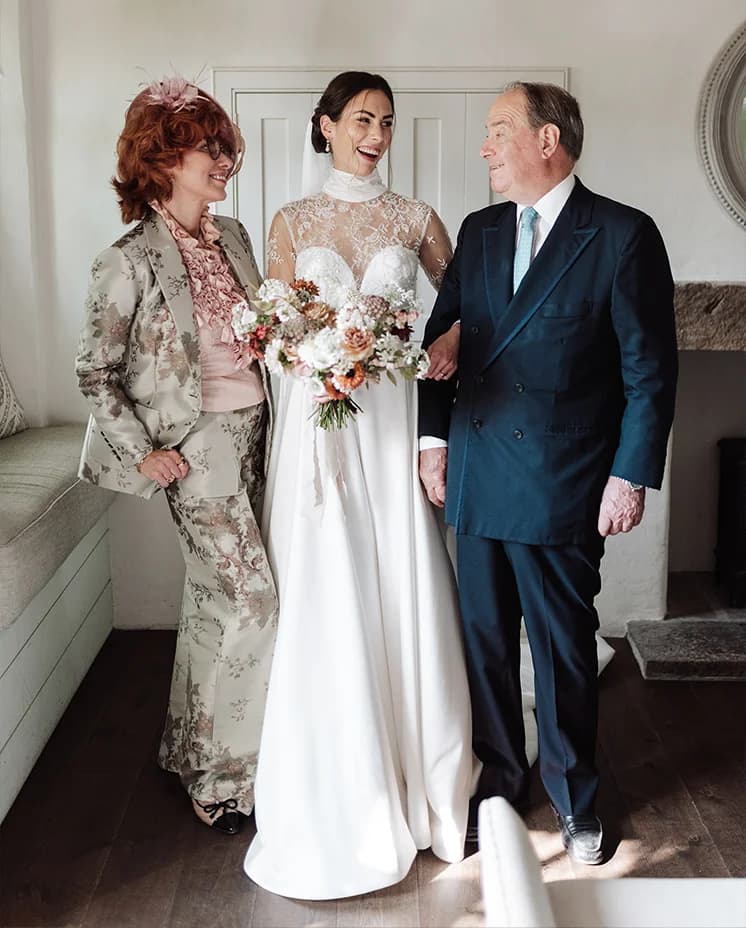 Bride poses with her parents ahead of her wedding ceremony