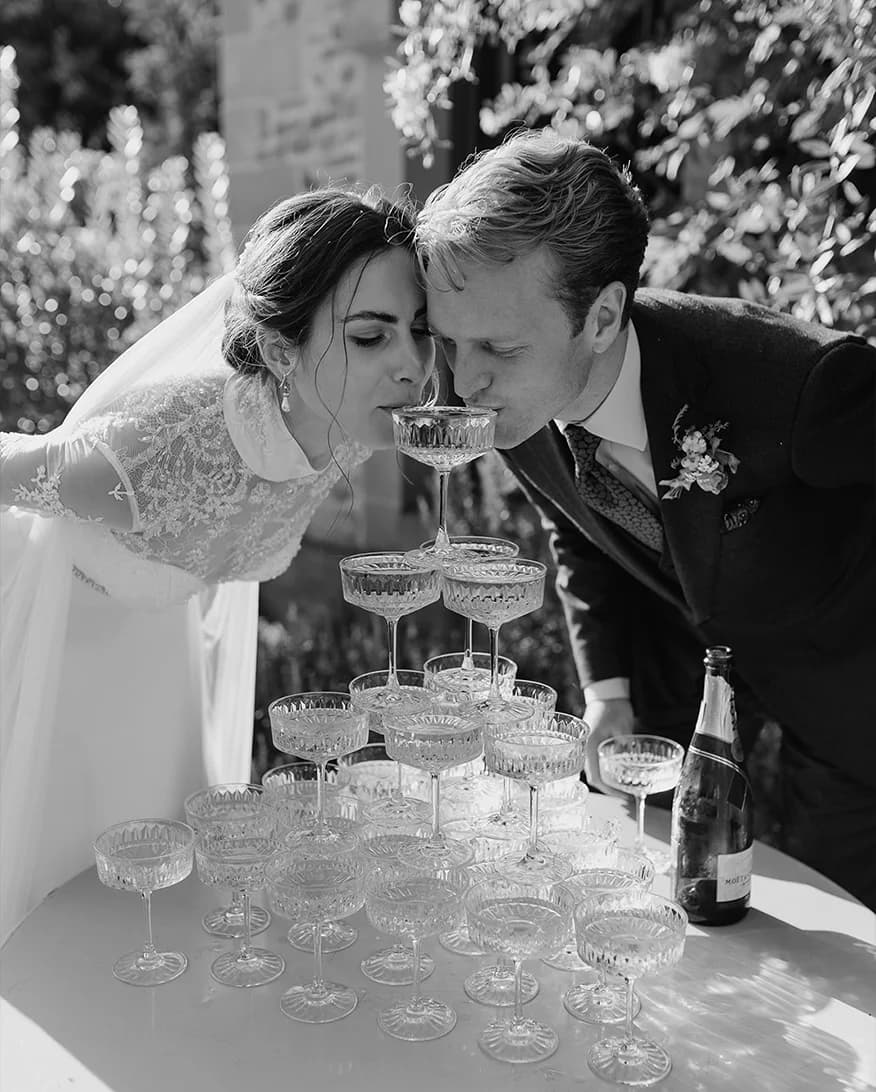 Bride and groom sip from their champagne tower outside The Fig House at Middleton Lodge Estate