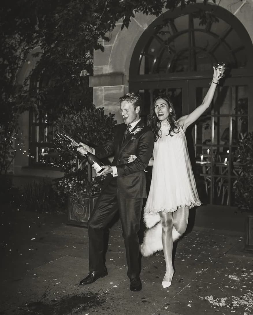 Bride and groom pop the champagne to celebrate