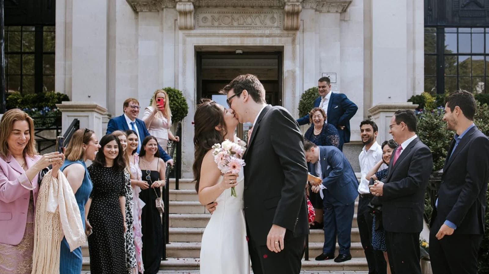 Just-married couple kisses outside the Islington Town Hall