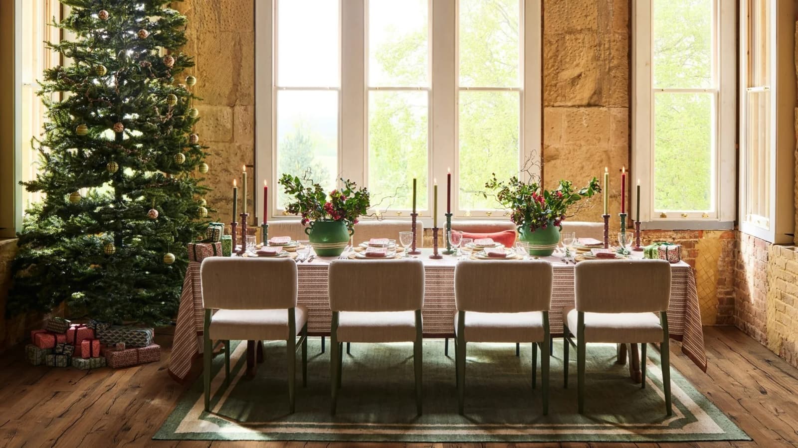 Beautifully set Christmas table next to a Christmas tree