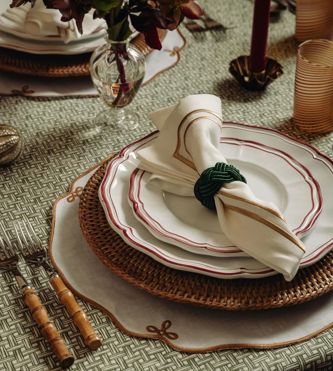 A table-setting with rattan placemat, elegant plates and styled napkin