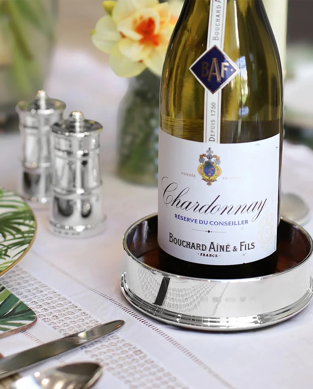 A silver wine coaster placed on decorated Christmas table