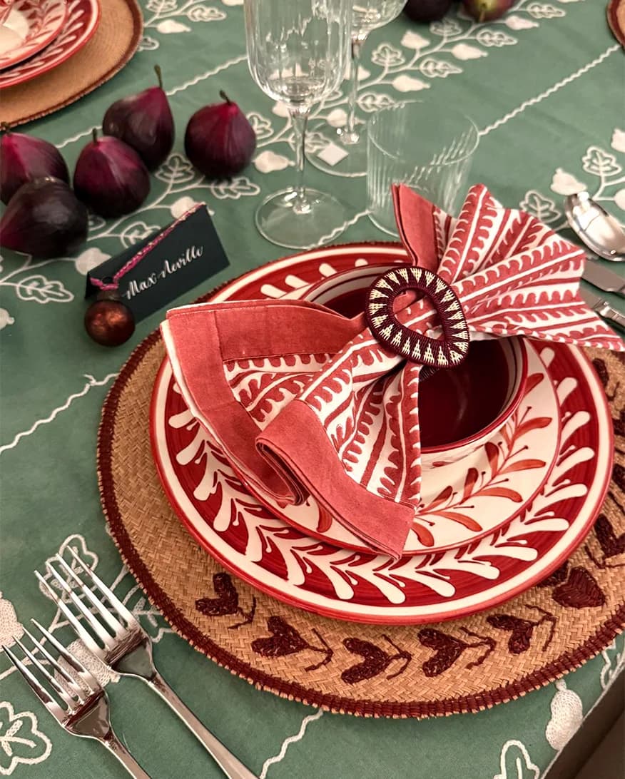 A Christmas table setting with handpainted plates and bow in napkin ring