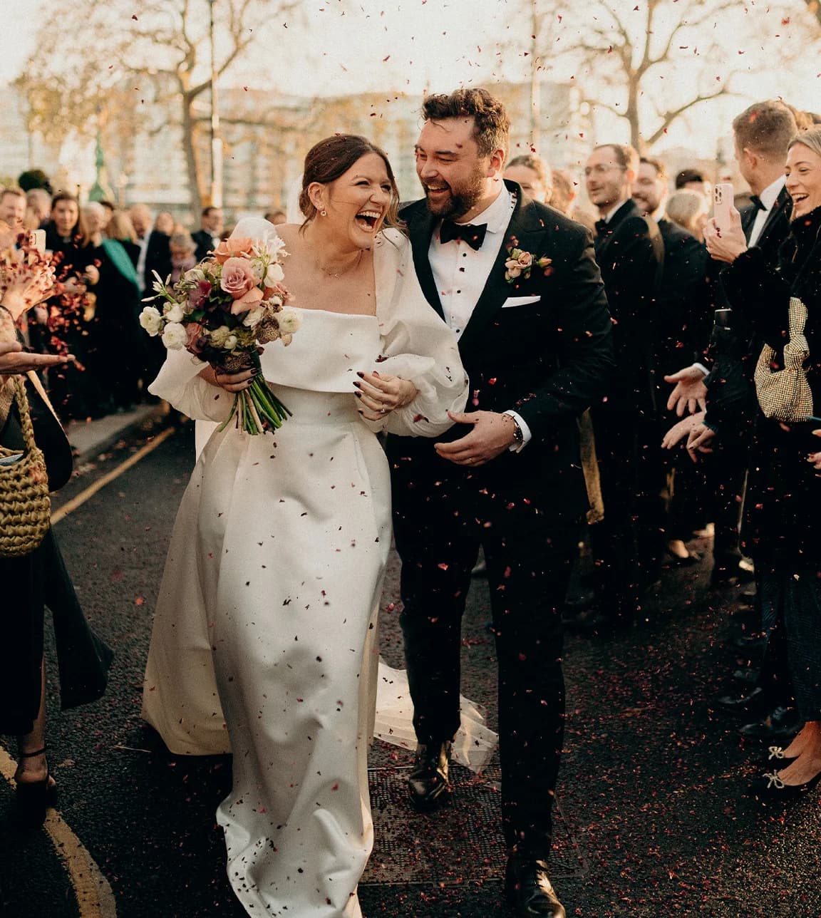 Bride and groom walk through confetti after their winter wedding ceremony in London