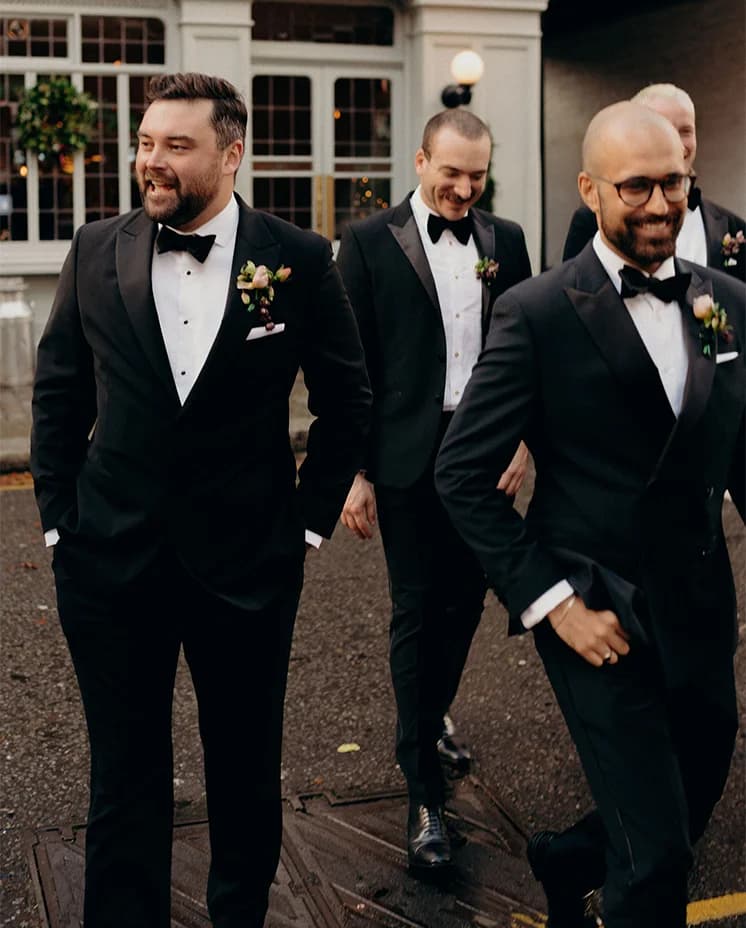 Groom and groom party stand outside London pub