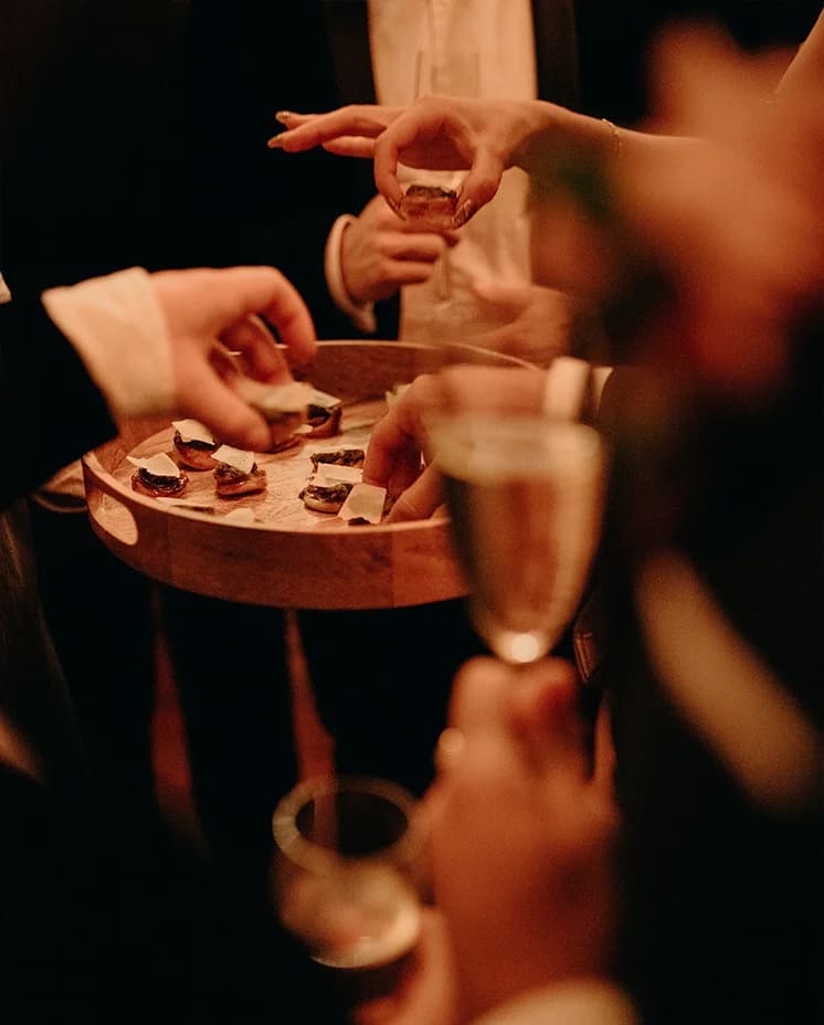 Guests take canapes served by wedding caterers, Doggart & Squash