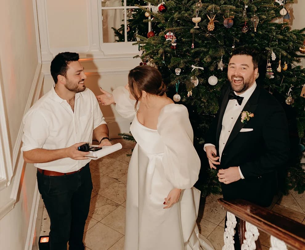 Bride and groom stand next to Christmas tree at The Belgravia