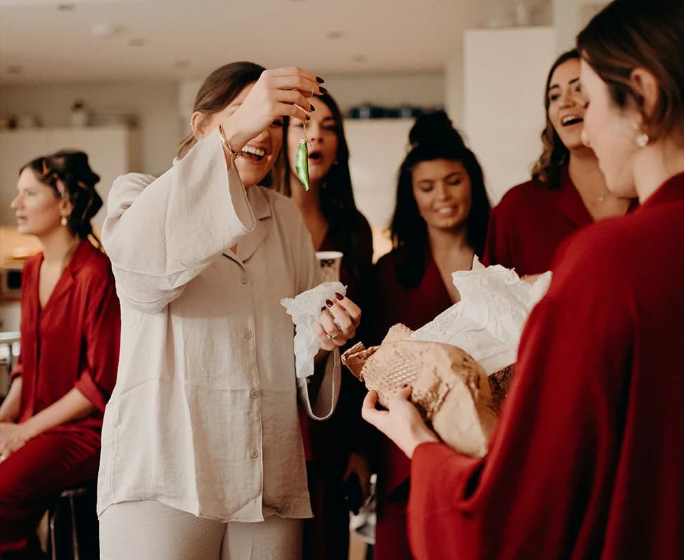 Bride unwraps her gift from bridesmaids, Christmas baubles