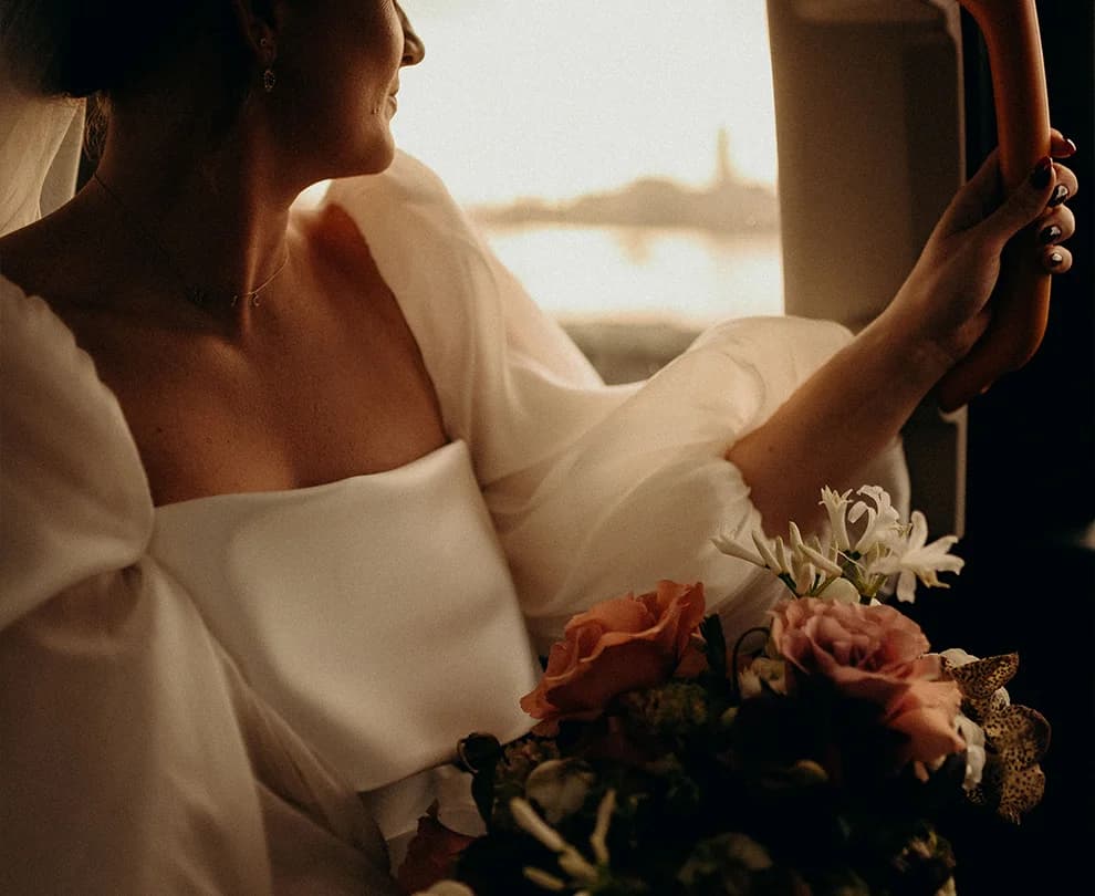 Bride sits in a cab, watching London streets outside the windows