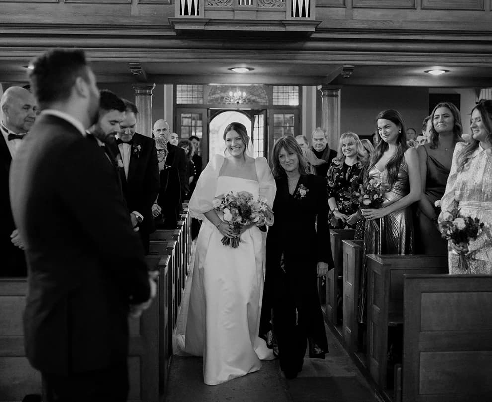 A bride walks down the aisle with her mother