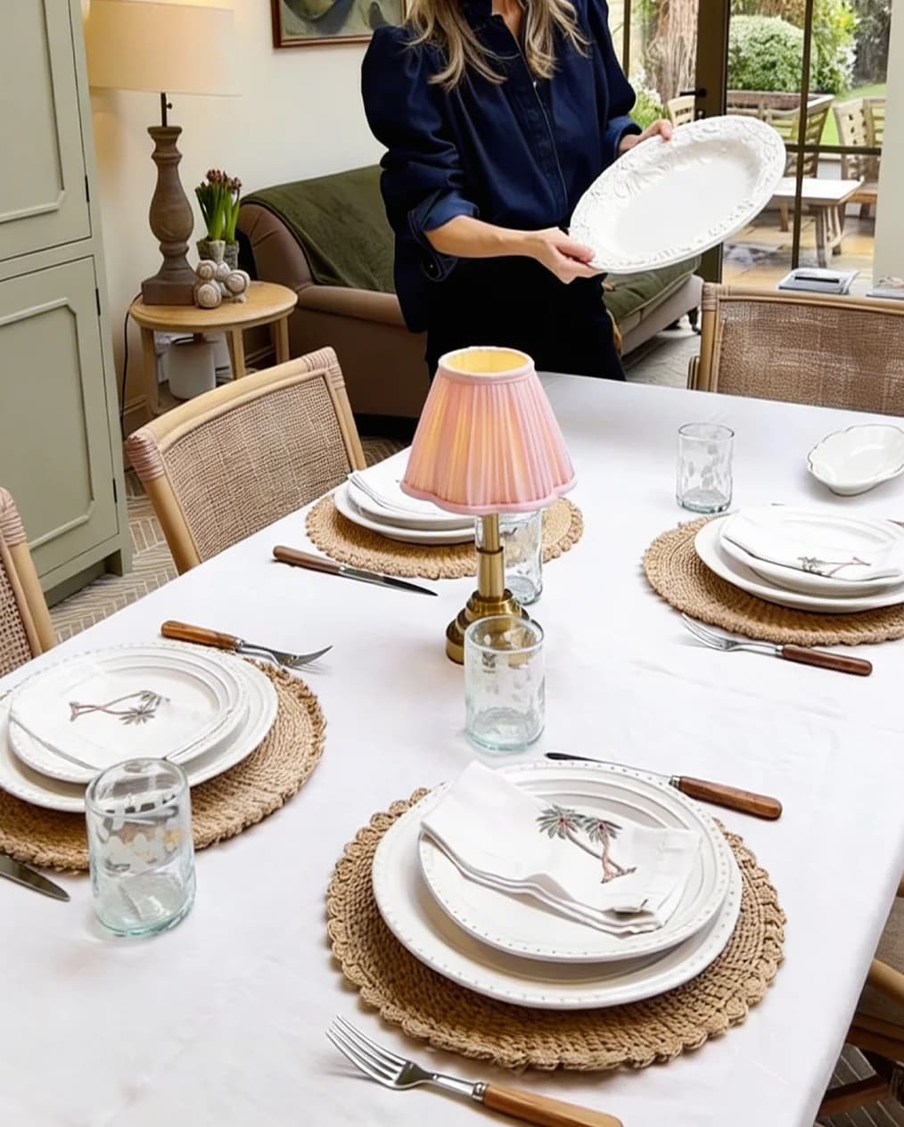 A table set by Pip Hodgson's kitchen featuring woven placemats, rustic plates, rechargeable lamp, embroidered napkins and speckled glassware