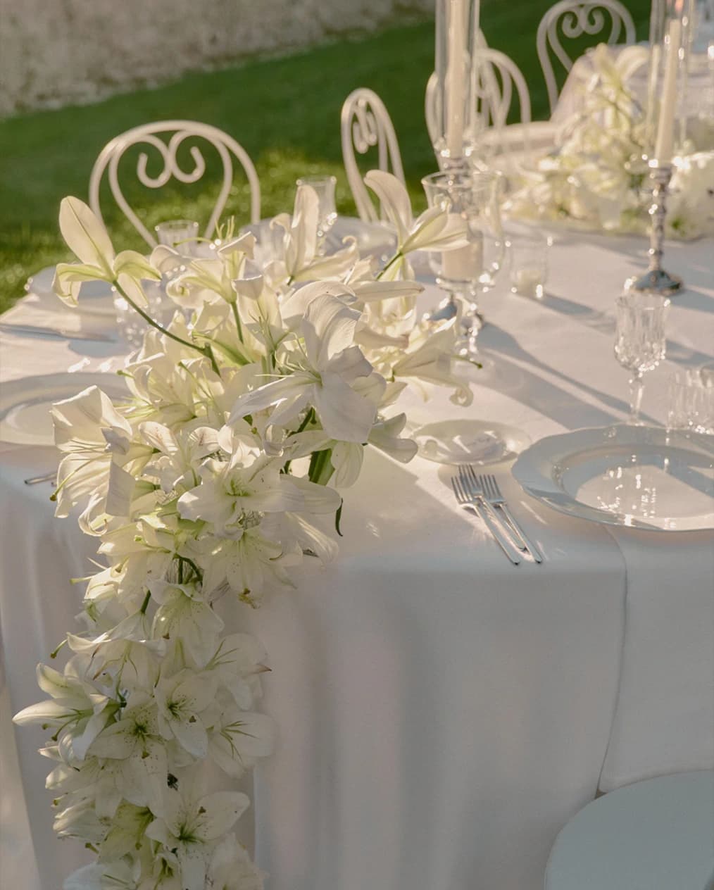 Elegant wedding tablescape at Villa Cetinale, featuring cascading white lily arrangements over crisp linens with refined glassware and place settings.