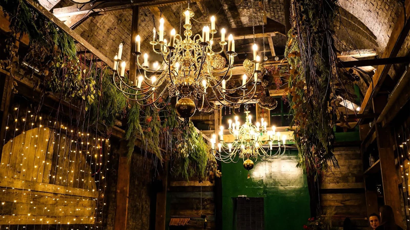 Old Timber Store London wedding venue with rustic interiors, chandeliers, hanging greenery, and warm fairy lights