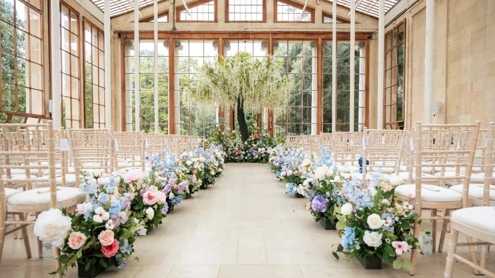 Wedding ceremony at Kew Gardens Nash Conservatory London with floral aisle décor and bright glasshouse setting
