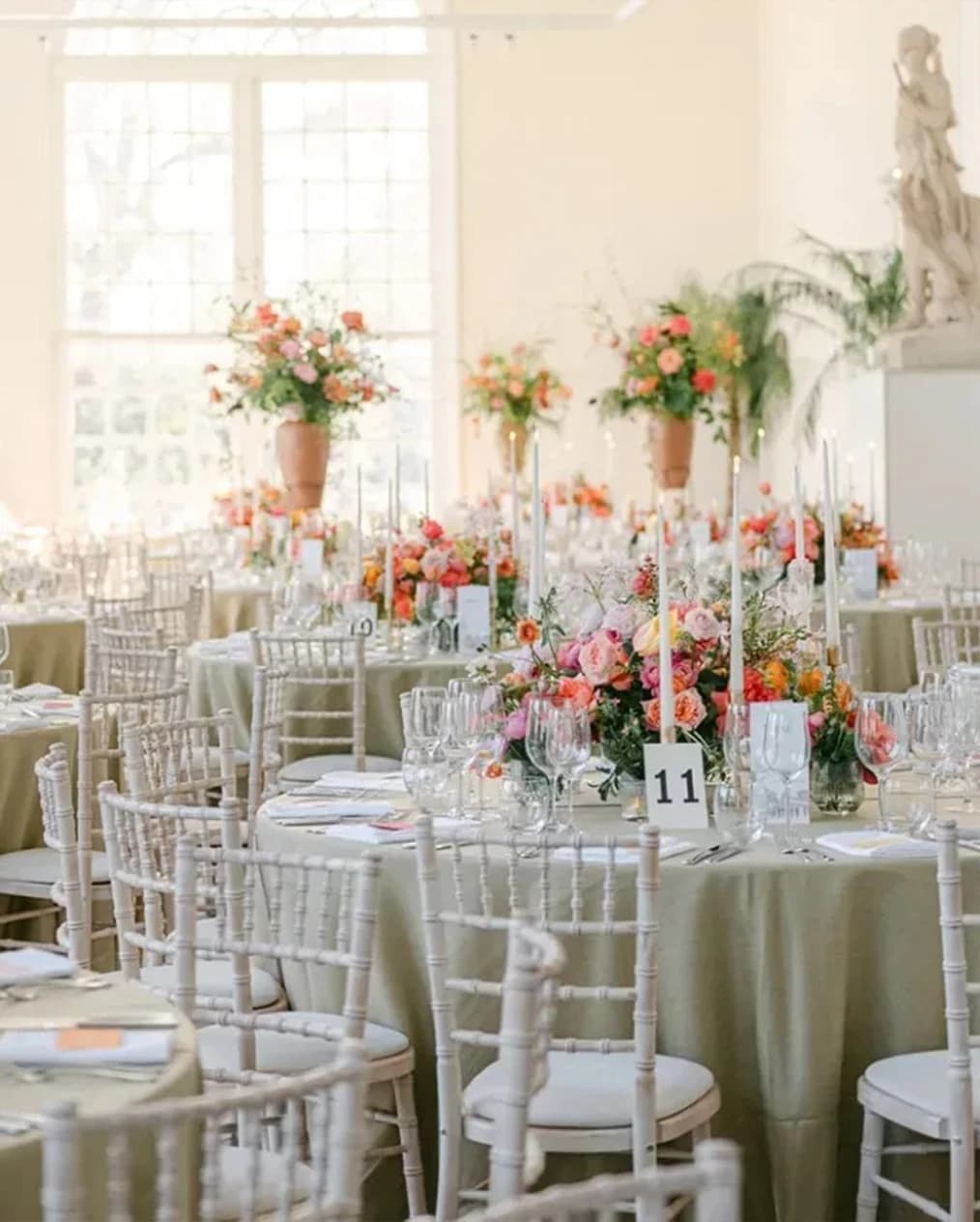 Wedding reception at Kew Gardens Orangery London with floral centrepieces, round tables, and elegant light-filled interiors