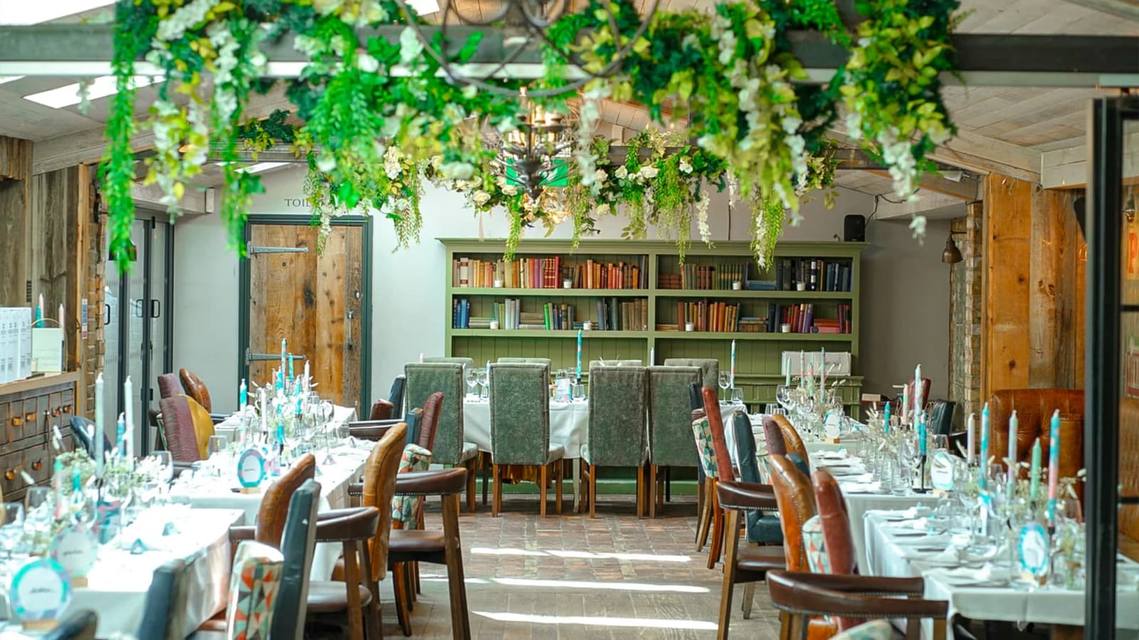 Wedding reception at The County Arms Wandsworth London with greenery ceiling décor, rustic interiors, and elegant table settings