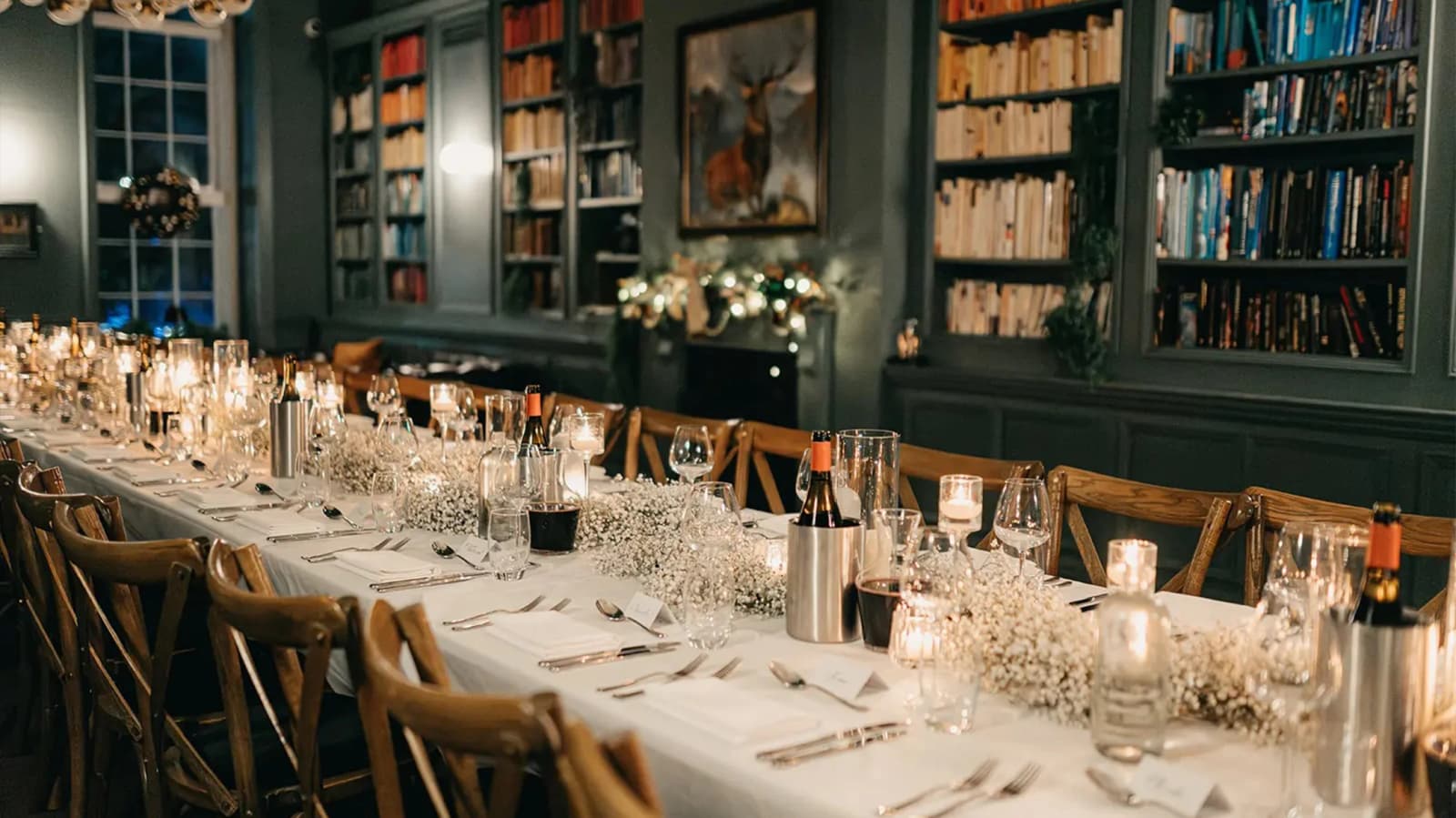 Wedding reception at Kindred Hammersmith London with long banquet table, candlelight, and cosy library-style interior
