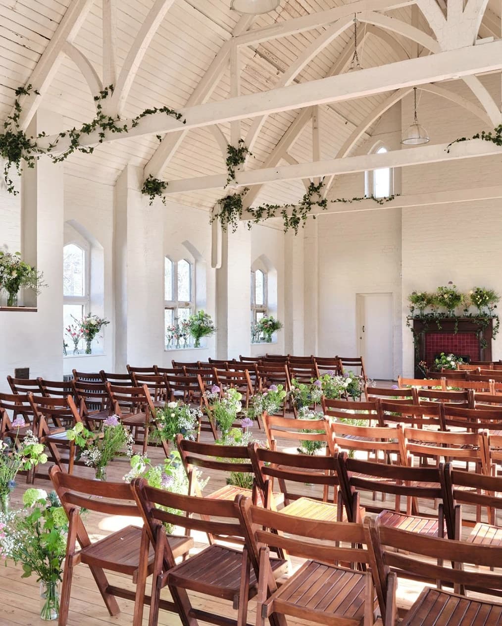 The Organ Factory London wedding venue with ceremony setup, rustic chairs, greenery, and white industrial space
