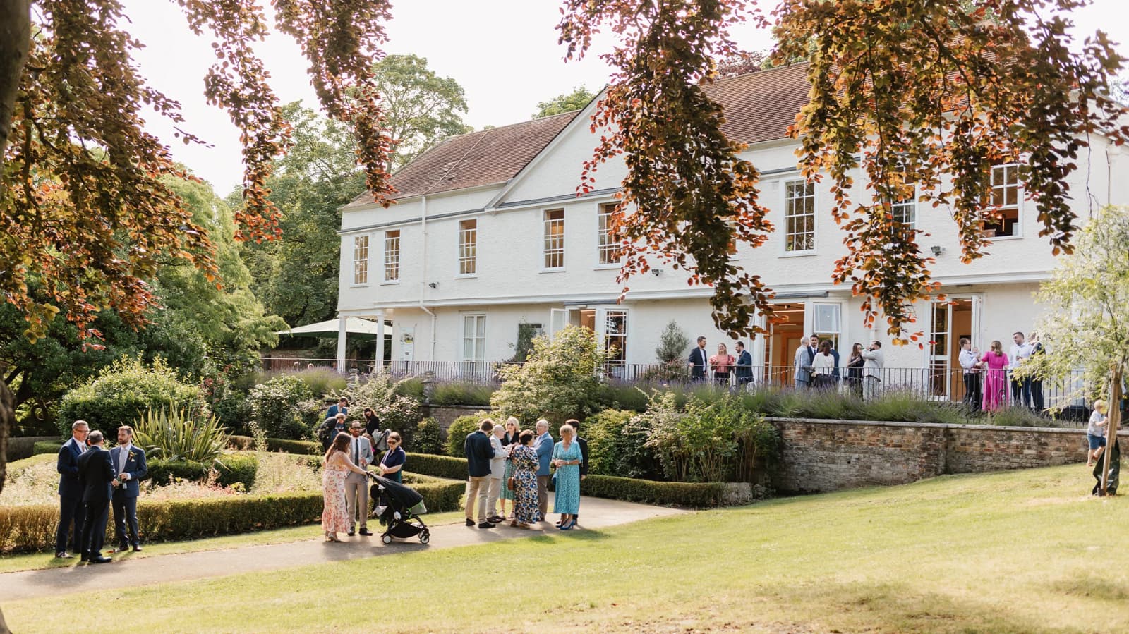 Wedding guests enjoying the garden at Lauderdale House Camden featuring a historic house and landscaped grounds