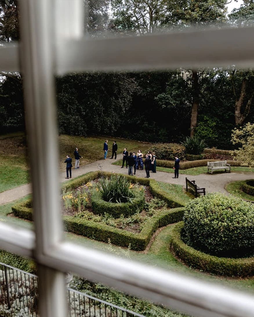 Wedding guests in the garden at Lauderdale House Camden London with landscaped grounds and outdoor setting