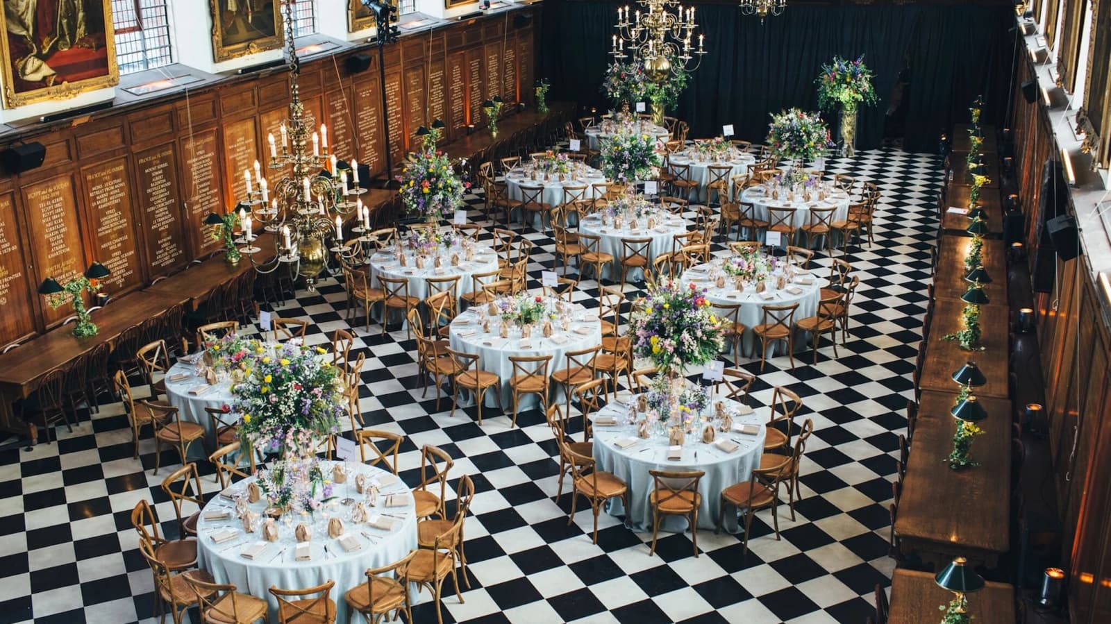 Wedding reception at Royal Hospital Chelsea London with grand hall, checkered floor, and floral table arrangements