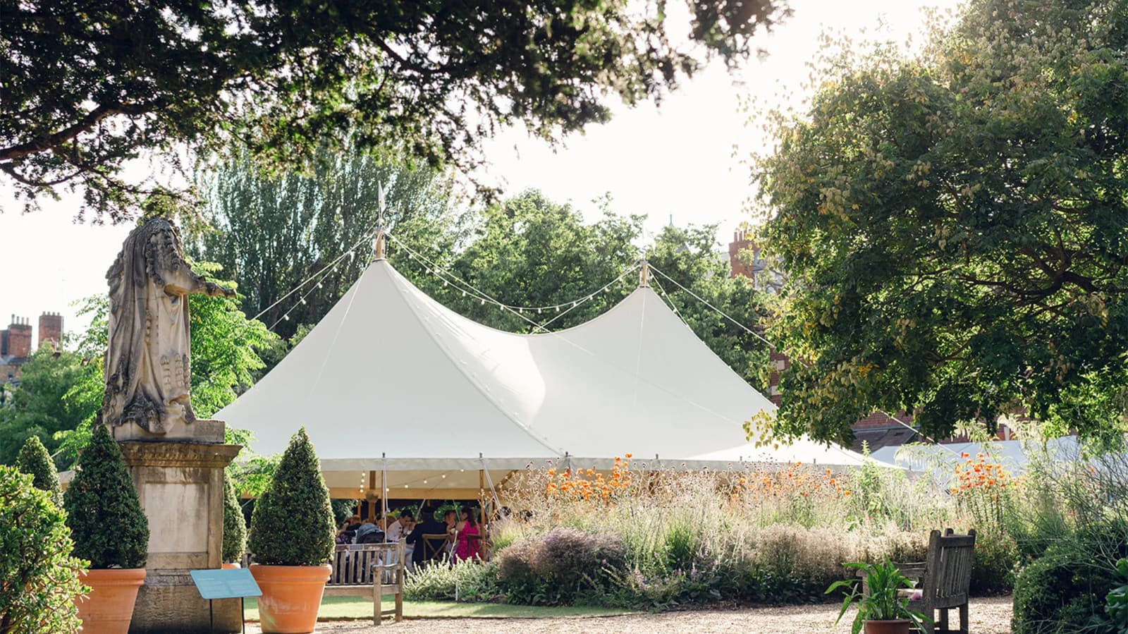 Wedding reception at Chelsea Physic Garden London with outdoor marquee, lush gardens, and natural greenery