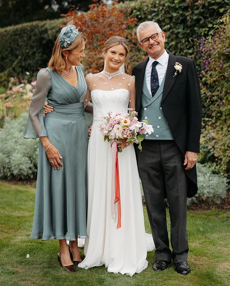 Honour Wainwright on her wedding day with her parents in the garden