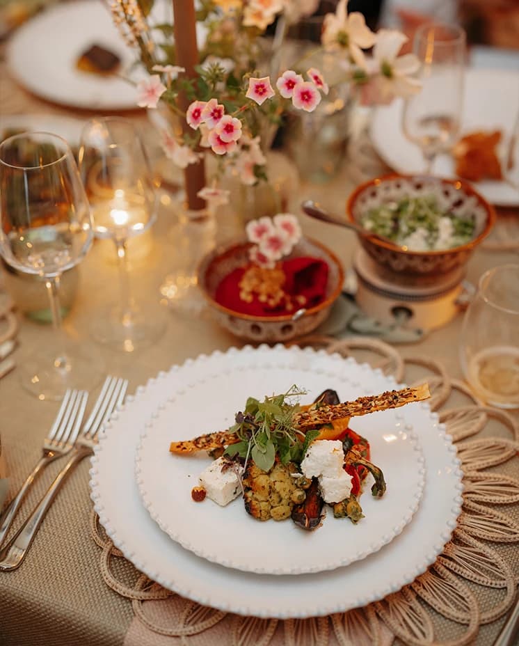 Seasonal plated wedding meal by Quince & Clover served alongside romantic floral centrepieces and candlelit reception décor.