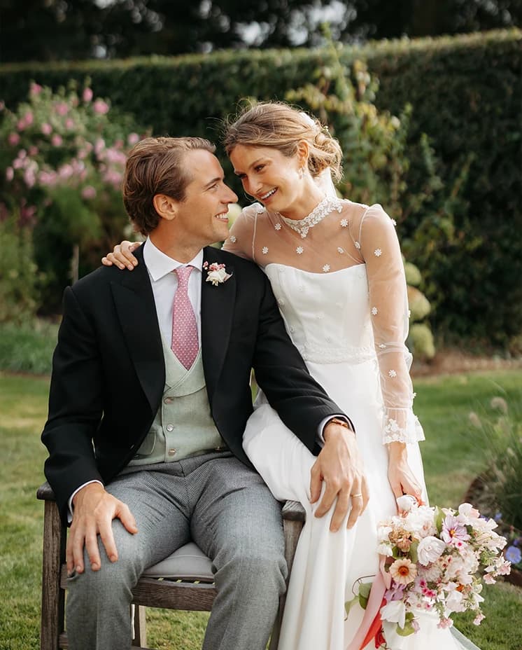 Bride and groom sharing a romantic moment in a garden, with the bride holding a seasonal bouquet during their countryside wedding
