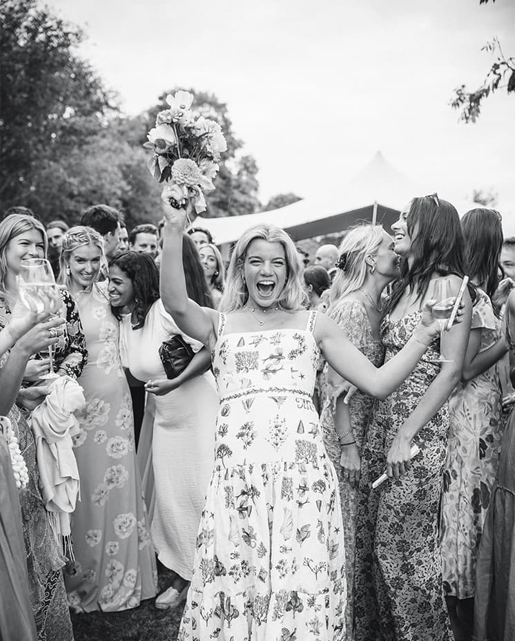 A wedding guest caught a bridal bouquet at summer marquee wedding