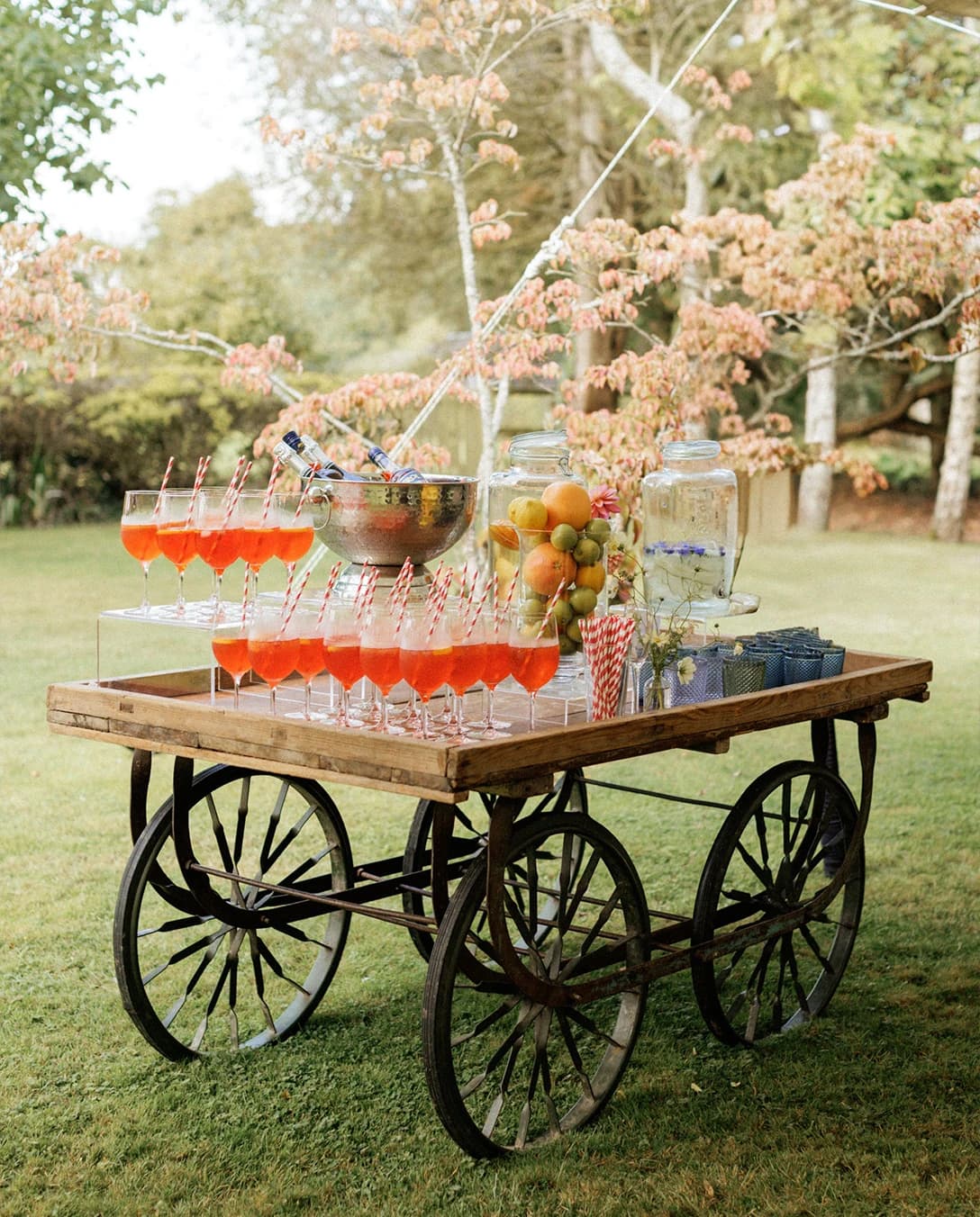 Vintage drinks cart serving Aperol Spritz and refreshments, creating a stylish outdoor drinks station at an English countryside wedding reception.
