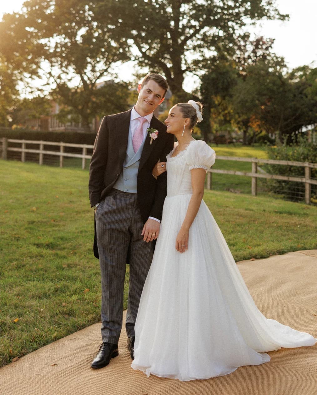Bride and groom sharing a golden hour portrait at their romantic Hampshire countryside wedding, with the bride in an elegant wedding dress and the groom in a classic morning suit.