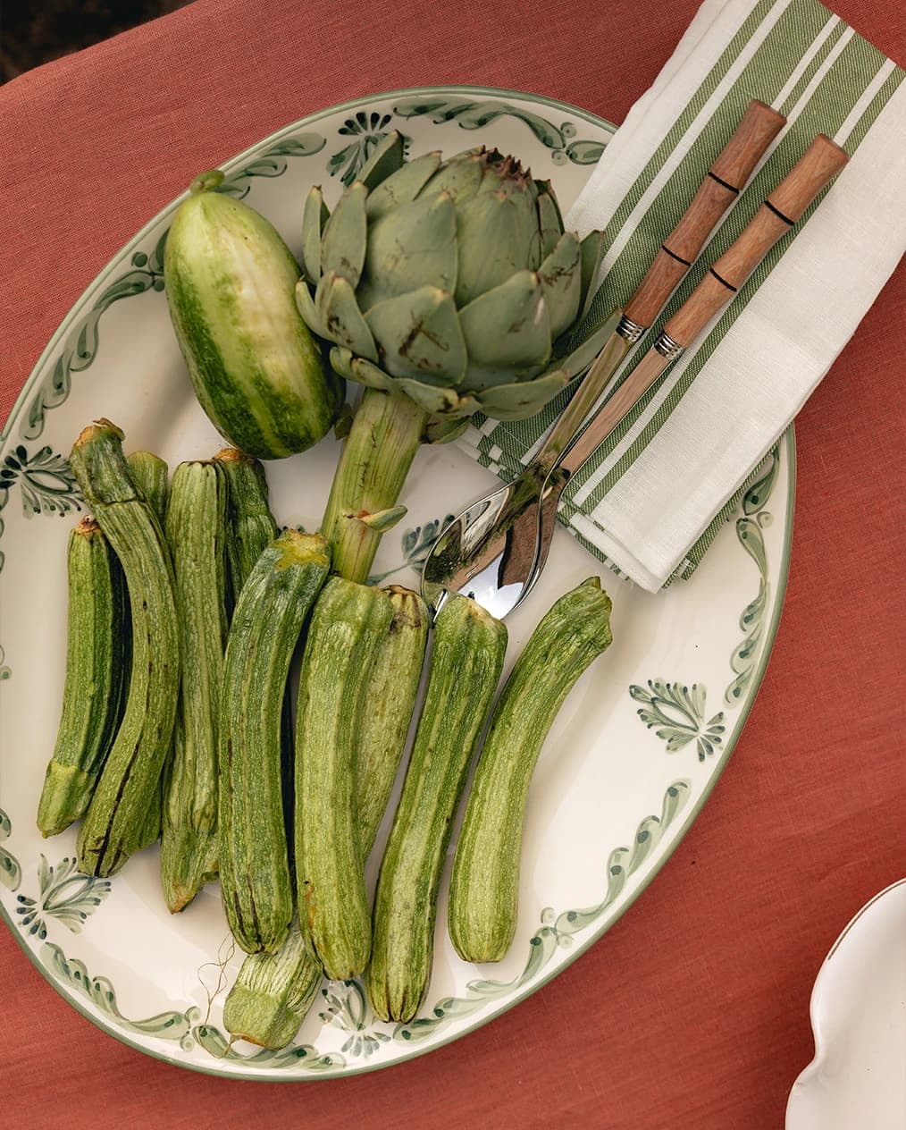 A vegetable served on Rebecca Udall serving platter with green hand-painted motives