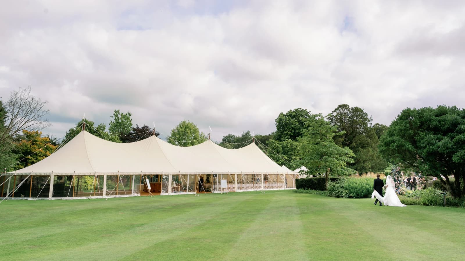 Newlyweds walking to the marquee set in the family garden
