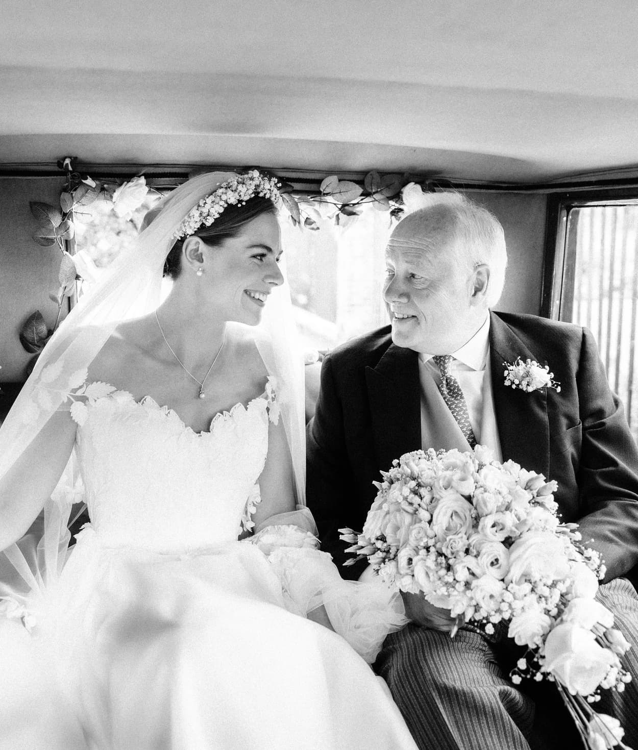 Bride and her father sit in the vintage wedding car