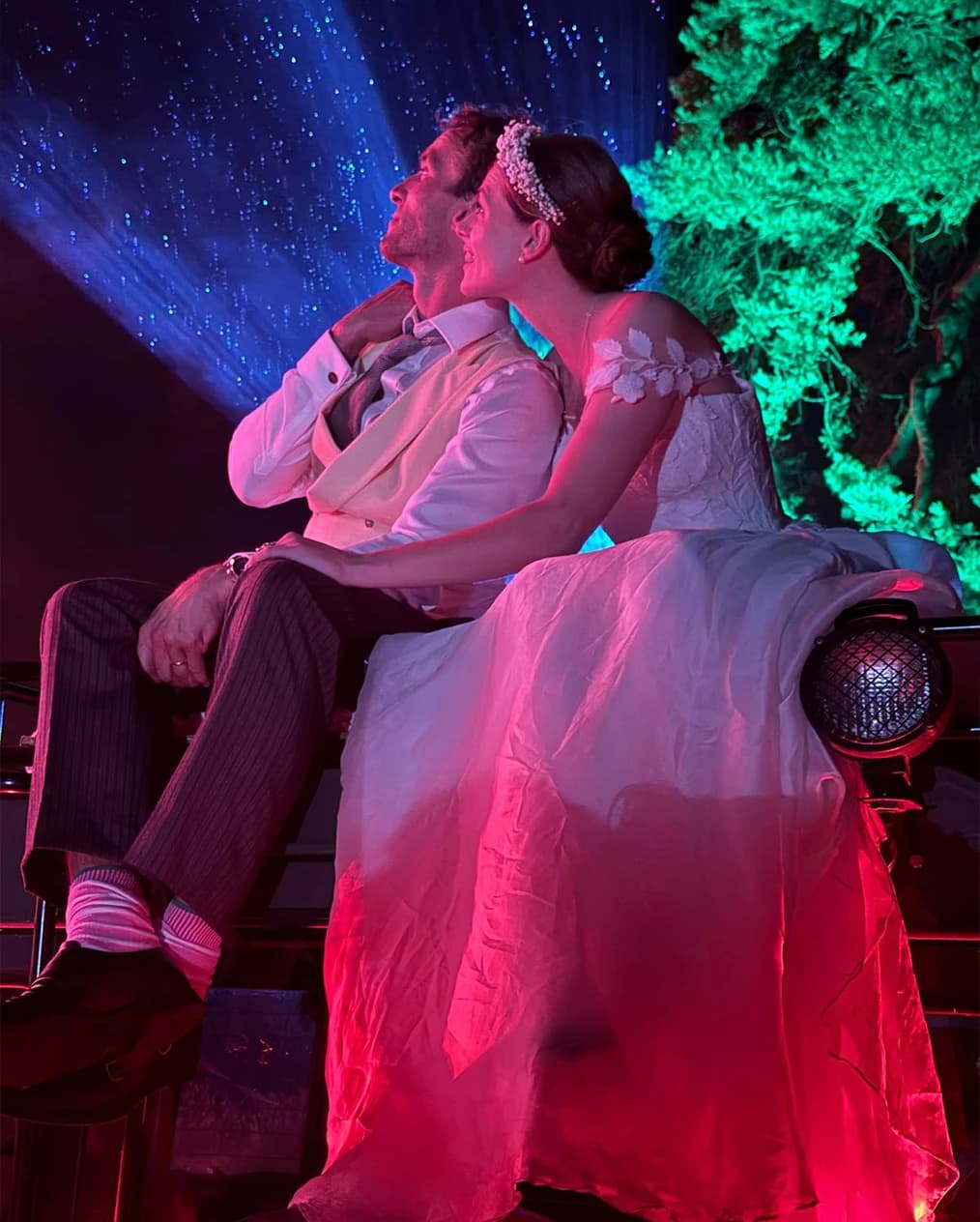 Bride and groom sitting on Land Rover and stargazing