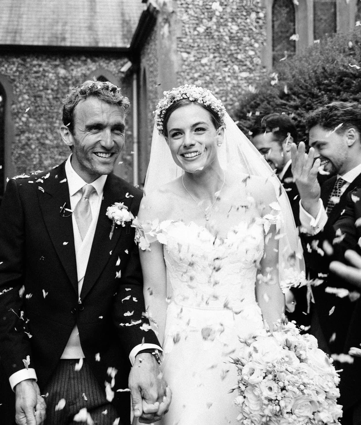 Bride and groom walk in confetti 