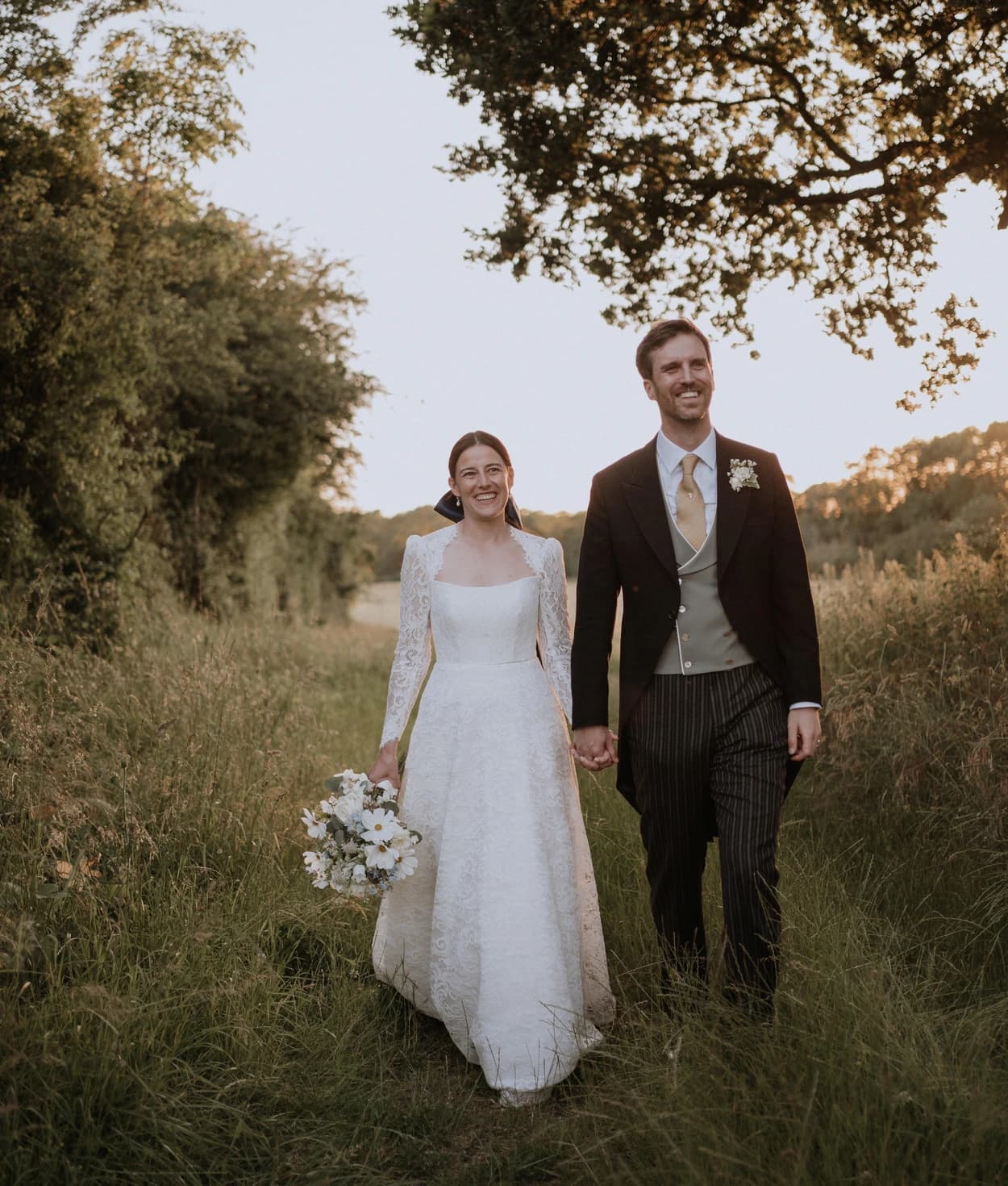 Sophie Breitmeyer and her husband walk through countryside on their wedding day