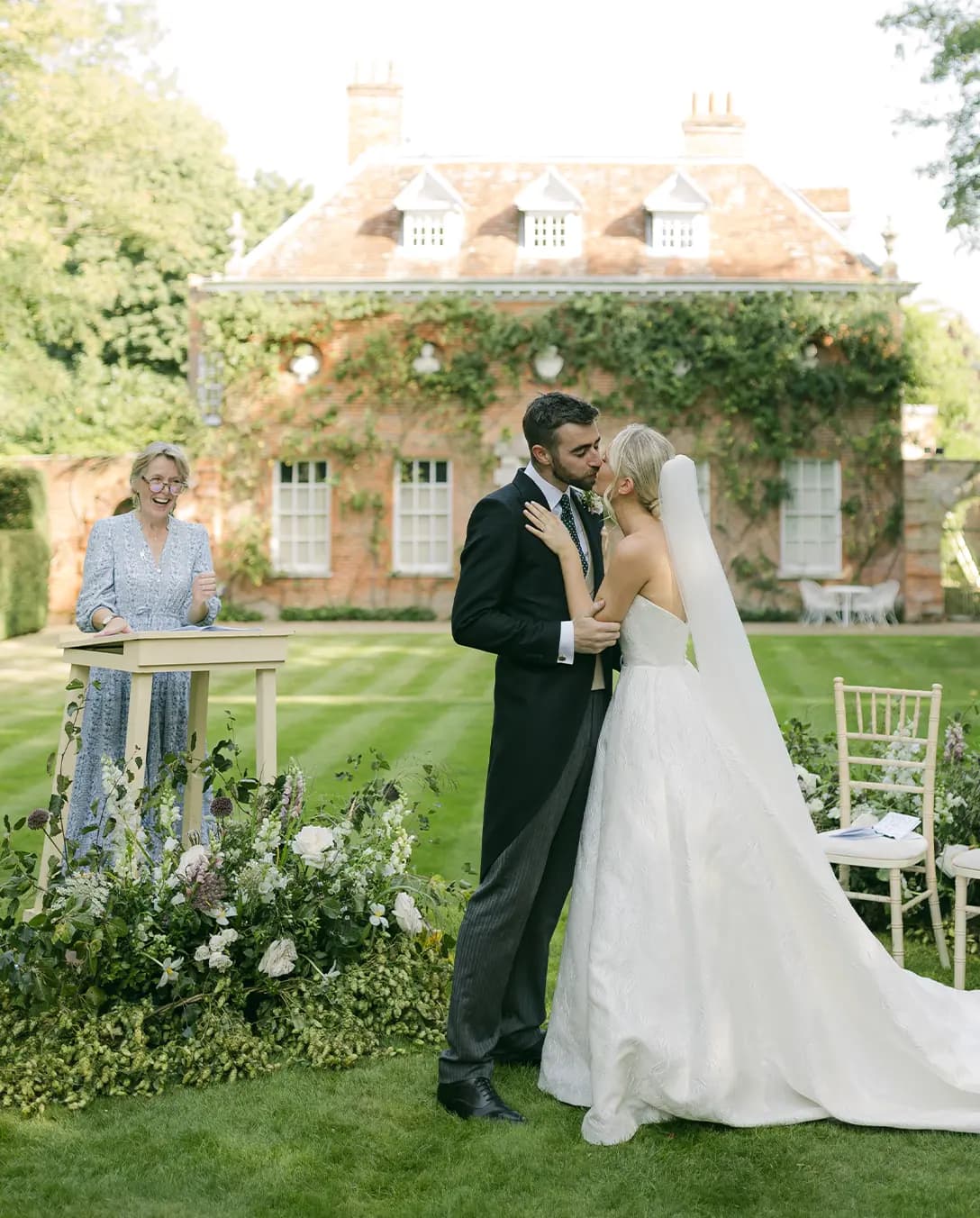 Celebrant gives modern reading during a wedding ceremony in English-style garden